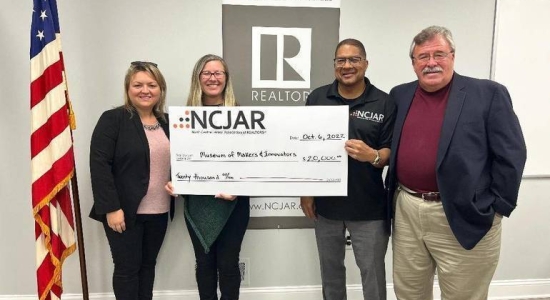 NCJAR presents MOMI president Sara Sorenson with donation check
